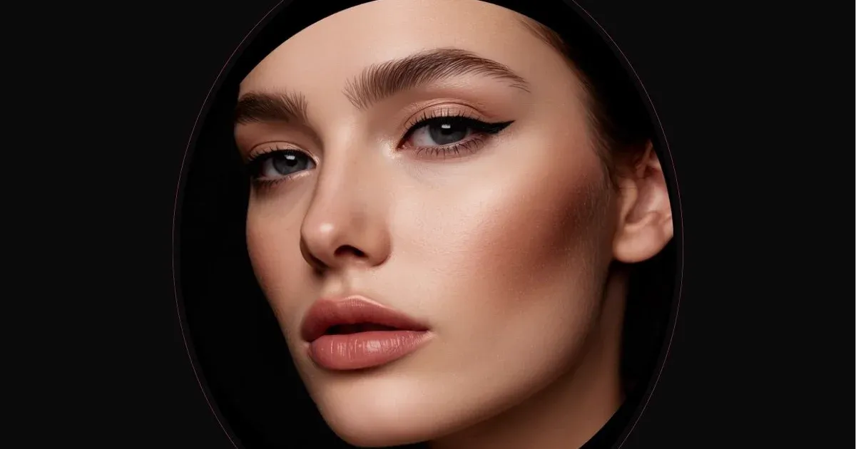 Makeup brush applying SPF foundation on a model's face.
